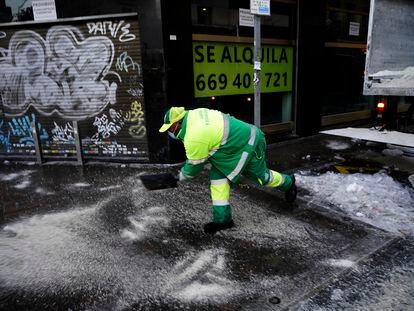 Un operario esparce sal en una acera de la calle Bravo Murillo