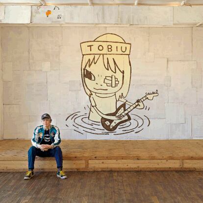 El artista, retratado ante uno de sus murales.