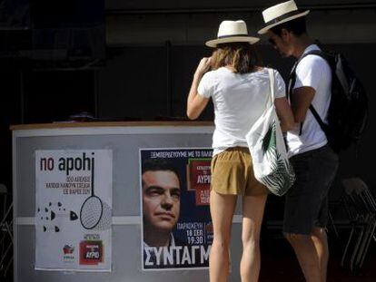 Touristas frente a un puesto electoral de Syriza, hoy en Atenas