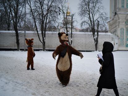 Serguéi, de 27 años, trata de arañar algo de dinero posando vestido de oso para fotos de recuerdo junto a la catedral de Santa Sofía, este jueves en Kiev.