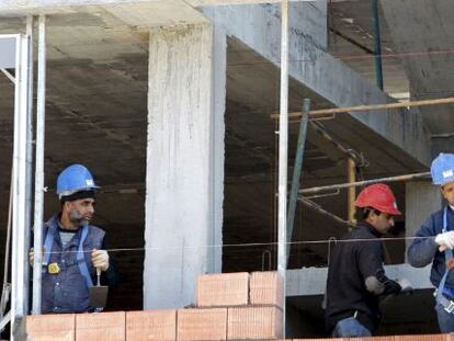 Tres obreros trabajan en la construcci&oacute;n de una vivienda de Bilbao.