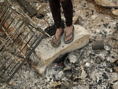 Una joven, sobre las ruinas calcinadas de la casa del novio de su madre tras los incendios en Redding (California).