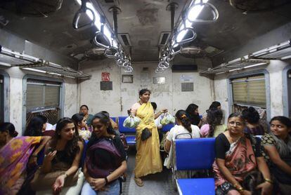 Una vendedora ambulante de verduras muestra sus productos a las viajeras de un vagón especial para mujeres en Bombay.