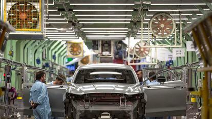Varios trabajadores de la planta de pintura de Ford en Almussafes revisan una carrocería.