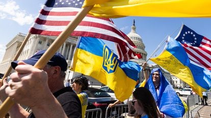 Partidarios de Ucrania agitan banderas en el exterior del Capitolio después de que la Cámara de Representantes aprobara el sábado nuevos fondos para el país invadido.