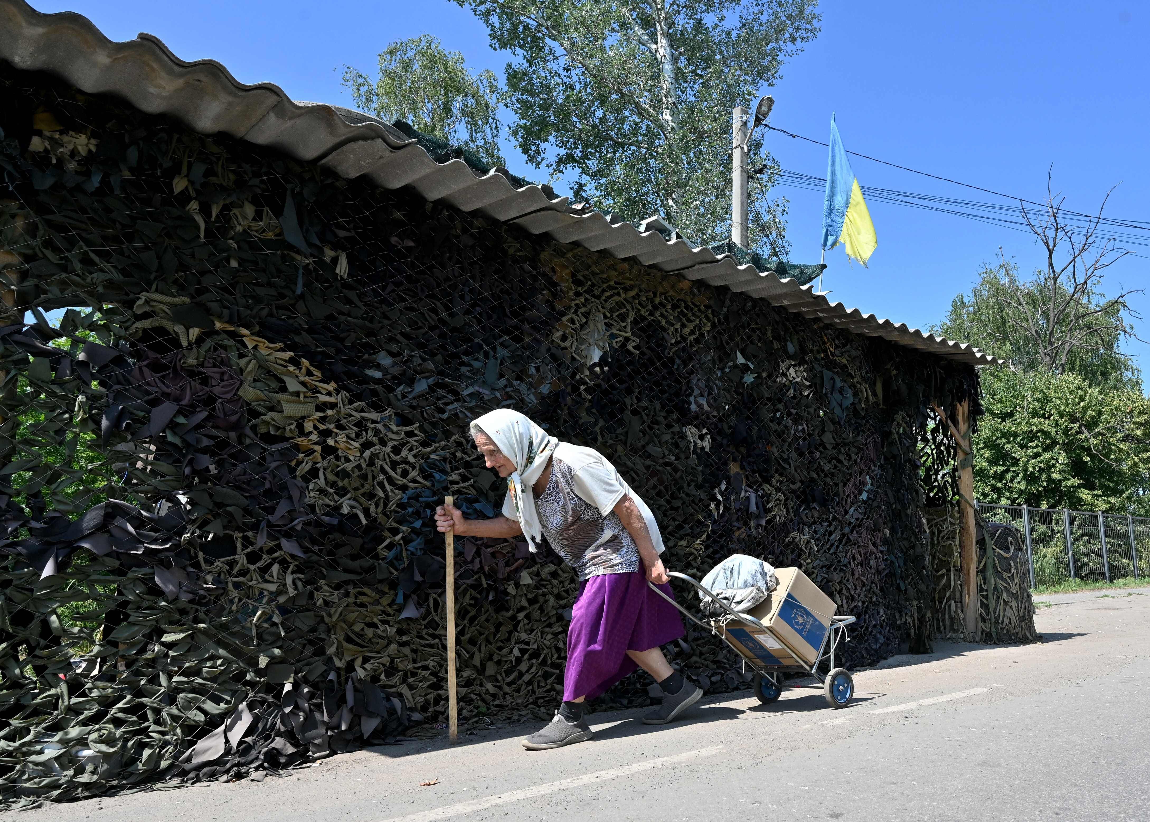 Una mujer carga con una caja de ayuda humanitaria en la localidad de Liptsy, en la provincia de Járkov.