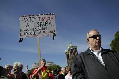 Un hombre envuelto en una bandera española, porta una pancarta contra Rojoy.