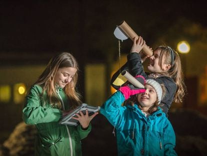 Unas niñas utilizan el telescopio casero para contar las estrellas en Suecia. 