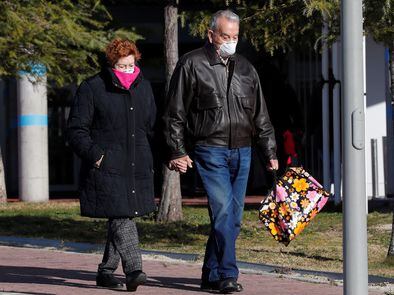 Una pareja con mascarillas vista en el exterior del Hospital de Torrejón de Ardoz.