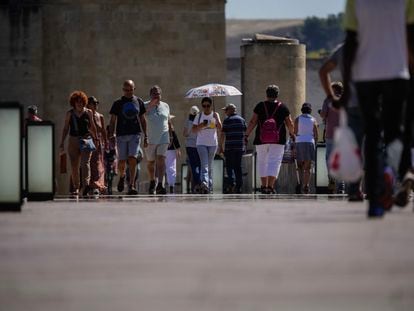 Un grupo de turistas pasea por el puente romano de Córdoba.