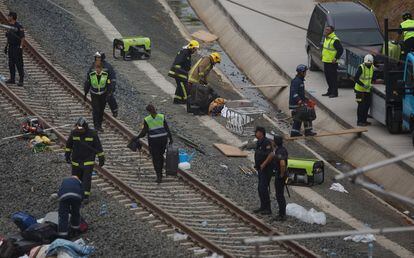 Equipos de emergencias limpian las vías del tren tras el descarrilamiento, 25 de julio de 2013.