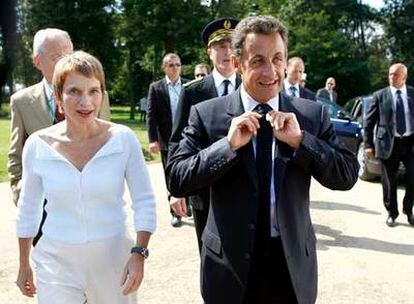 Nicolas Sarkozy se ajusta la corbata junto a la presidenta de la patronal francesa, Laurence Parisot.