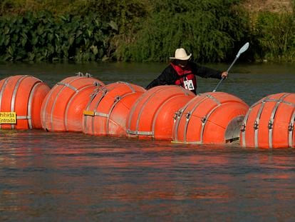 Un navegante de kayak pasa por detrás de la barrera contra migrantes colocada en el Río Grande (Texas) el 1 de agosto 2023.