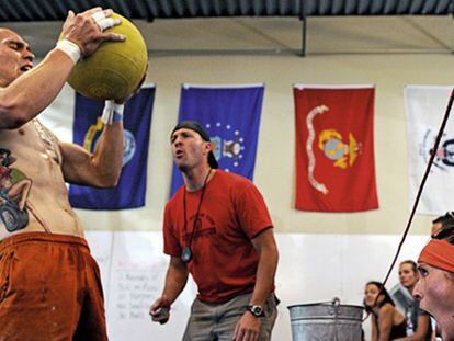 Deportista de crossfit, sosteniendo un balón medicinal.