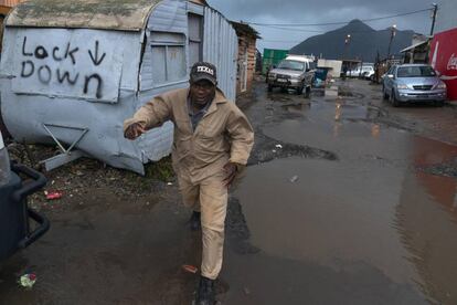Ciudad del Cabo, en Sudáfrica. Un hombre corre por las calles inundadas del suburbio de Masiphumelele, donde están sufriendo un clima invernal, con fuertes lluvias y viento, en estos días de junio ya de desconfinamiento.