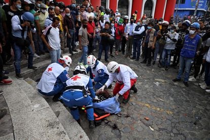 La Cruz Roja Colombiana recoge el cuerpo del fiscal que fue linchado tras disparar contra dos manifestantes.
