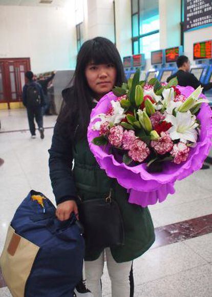 Gong Zhuling, auxiliar administrativa de 28 años, espera que el ramo de flores que espera regalar a su madre aguante las ocho horas de viaje.