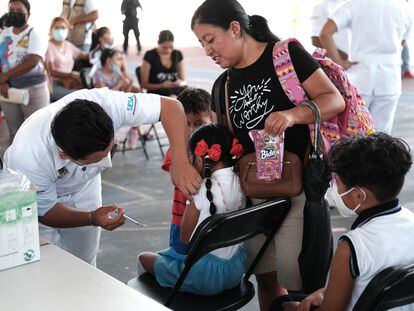 Una niña recibe el refuerzo de la vacuna contra la covid-19, en un colegio en Cancún.