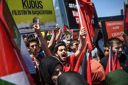 Miembros y partidarios del partido AKP levantan banderas palestinas y turcas y pancartas que leen "Al-Quds (Jerusalén en árabe) capital de Palestina" mientras gritan consignas frente al consulado de Israel en Estambul, el 15 de mayo de 2018.  
