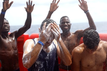 Un grupo de hombres se ducha en la cubierta del barco.  El 'Open Arms Uno' es un barco diseñado para realizar tareas de salvamento masivo y fue cedido por Enrique Piñeyro, filántropo argentino que inició su colaboración con Open Arms a través de la ONG Solidaire que dirige, con vuelos humanitarios a la India, Mozambique y Ucrania, según cuenta la propia ONG en su página web. El nuevo buque tiene un tonelaje más de 4 veces superior al viejo remolcador 'Open Arms' y una cubierta de 353 metros cuadrados en la que puede aterrizar un helicóptero en caso de emergencia y evacuación. 