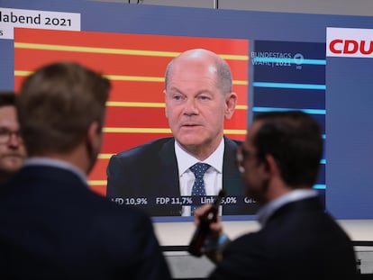 Militantes de la CDU siguen en la sede en Berlín el debate entre candidatos, con el socialdemócrata Olaf Scholz en pantalla.