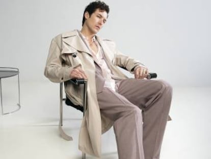 Jorge Suquet se abandona sobre una silla con gabardina Givenchy y traje y camisa Hugo. Colgante con sello Súarez.