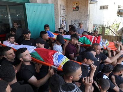 Un grupo de palestinos trasladan los cadáveres de dos hombres que murieron mientras manipulaban explosivos, el miércoles en el campo de refugiados de Balata, Cisjordania.