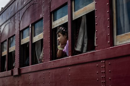 Une fille regarde par la fenêtre du train.