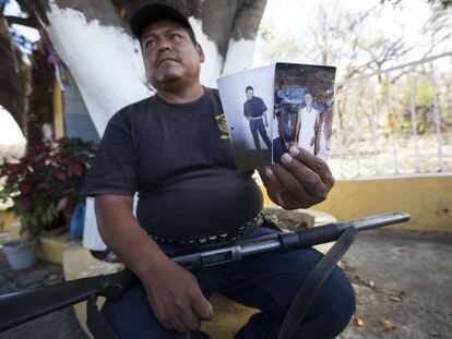 El líder de la policía comunitaria de Nuevo Balsas muestra fotos del capo local
