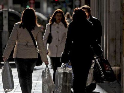 Varias mujeres pasean por una calle del centro de Valencia cargadas con bolsas con compras.