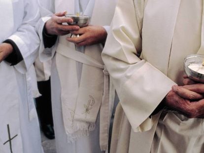 Sacerdotes con cálices durante una misa. 