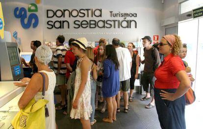 Varios turistas esperan a ser atendidos en la Oficina de Turismo de San Sebastián.