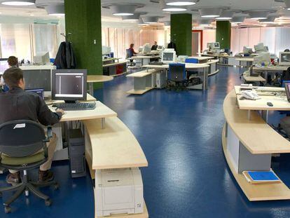 Empleados trabajando con ordenadores en una oficina.