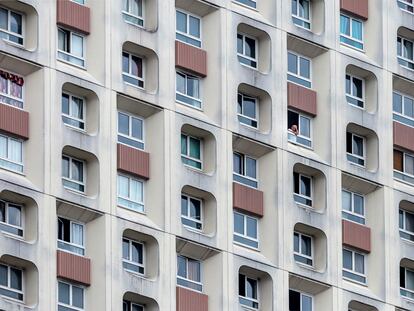 Un hombre mira por la ventana en un edificio de apartamentos de gran altura durante el segundo día de cierre ordenado por el gobierno francés para combatir el coronavirus el 18 de marzo de 2020 en París, Francia.