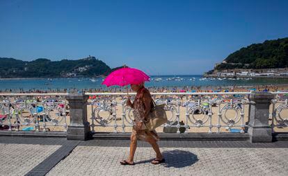 Una mujer pasea cubriéndose del sol junto a la playa de La Concha en San Sebastián, este miércoles.