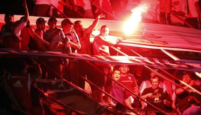 Seguidores de River Plate encienden una bengala durante un partido.