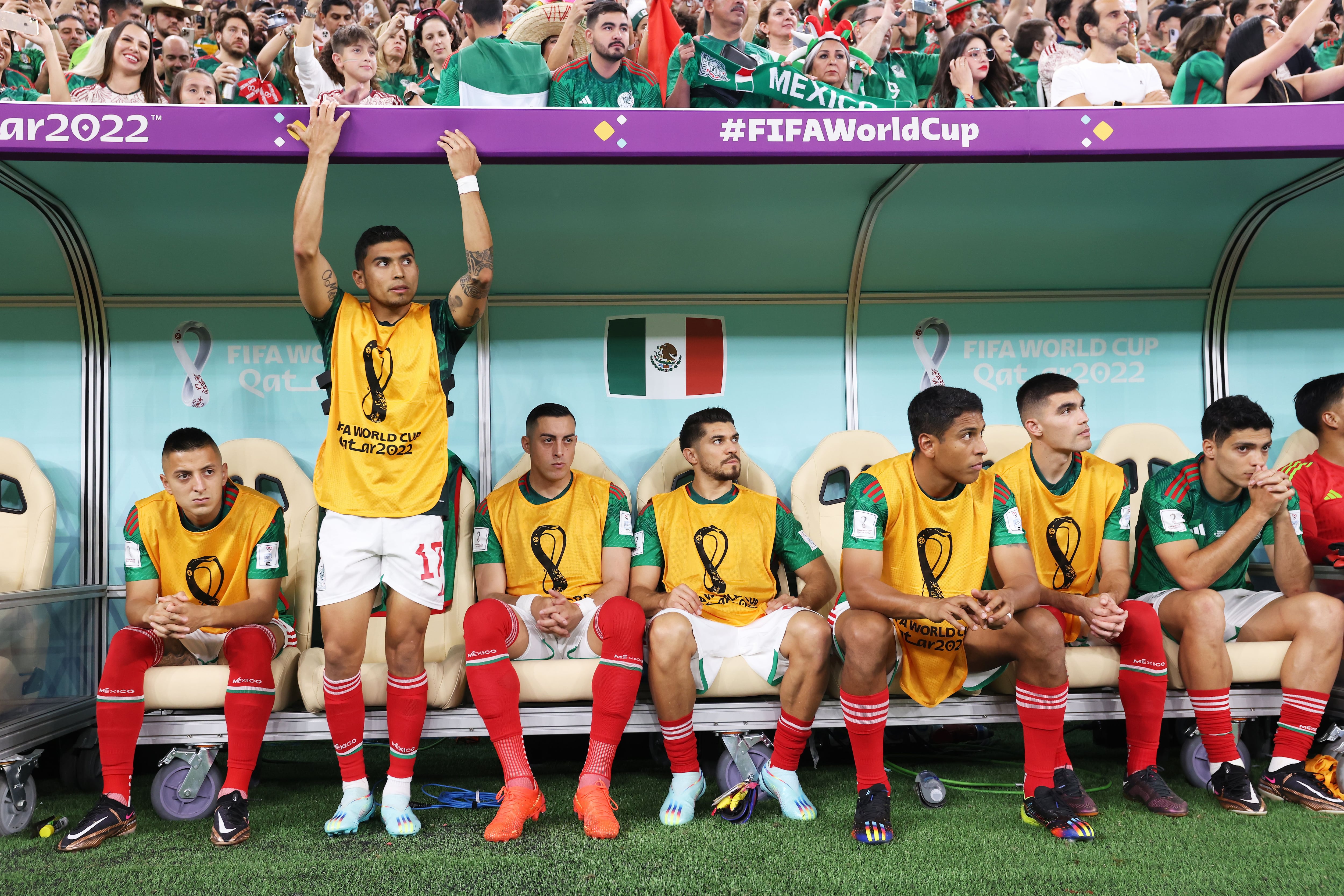 Los jugadores suplentes de México ven el partido desde el banquillo.