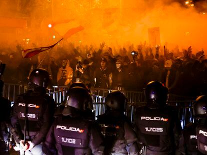 Un grupo de agentes, frente a la valla y a los manifestantes concentrados en los alrededores de la sede del PSOE en Madrid, este martes.