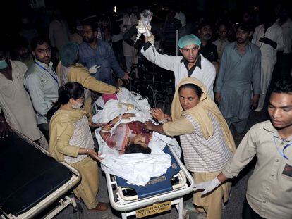Miembros del equipo de emergencia y algunos familiares trasladan a una mujer herida al hospital de Lahore.