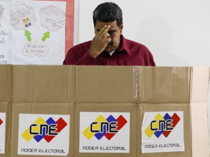 El presidente de Venezuela, Nicolás Maduro, se persigna mientras ejerce su voto en las últimas presidenciales, en Caracas el 20 de mayo de 2018.