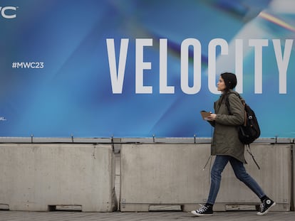 Una mujer camina junto a un cartel con el eslogan del MWC de la edición de este ano, 'Velocity', este sábado en los exteriores del recinto de la Fira de Barcelona.