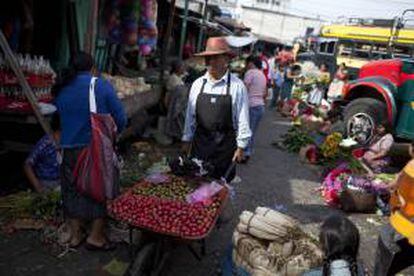 Un hombre ofrece frutas en el Mercado "La Terminal", en la Ciudad de Guatemala, durante la conmemoración del Día Internacional del Trabajo.