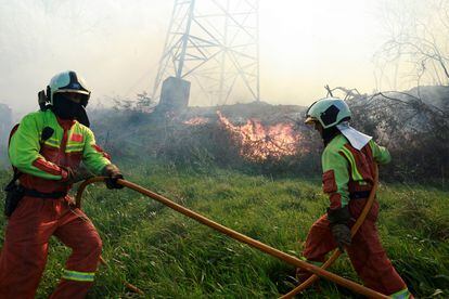 Bomberos intentan sofocar el incendio en Setienes (Asturias), el viernes.
