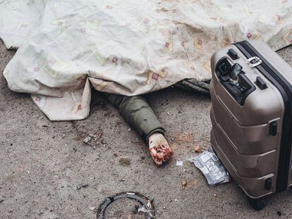 Una persona que intentaba huir junto a su familia yace en el suelo junto a su maleta tras un bombardeo ruso en el punto de evacuación de Irpin, el 6 de marzo.