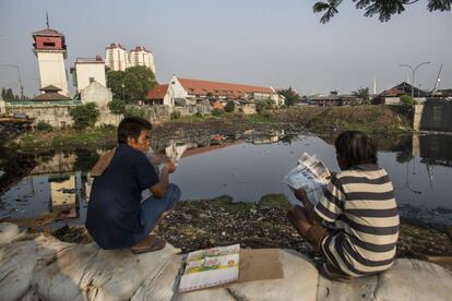 Los residentes hacen su vida sobre el antiguo malecón de 40 años de antigüedad cuando la carretera está mojada y sucia.