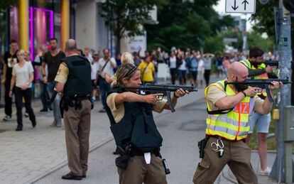 Los agentes de policía apuntan con sus armas de fuego hacia el centro comercial Olympia Einkaufzentrum, mientras son evacuados las personas que se encontraban en dicho centro.