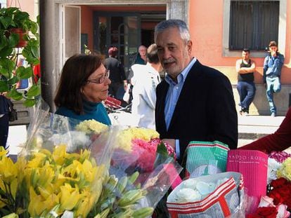 Griñán conversa en Motril (Granada) con una mujer en un puesto de flores.