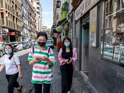 Transeúntes en la calle de Pelayo de Valencia, donde se han establecido numerosos comercios asiáticos. La instalación de unos arcos chinos en su entrada ha dividido a sus vecinos.