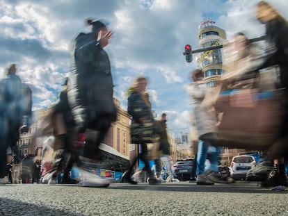 Un grupo de peatones cruza la Gran Vía de Madrid.