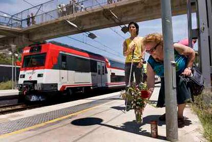 Una mujer deposita flores cerca del lugar del accidente ferroviario de Castelldefels.